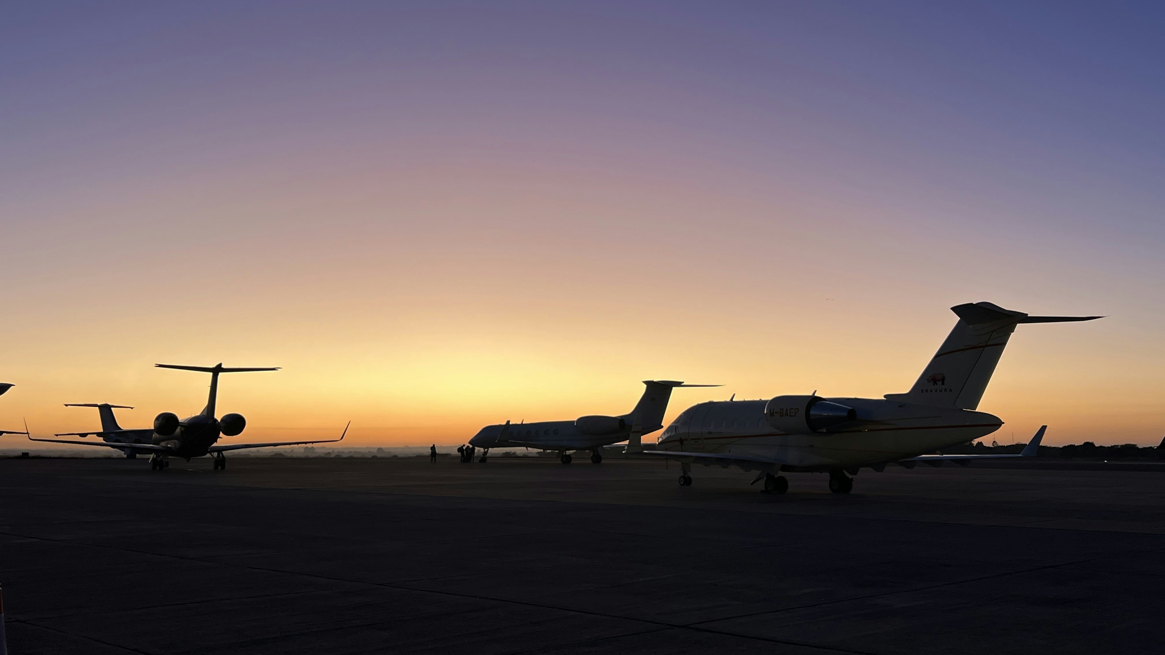 Luxury private jet flying above clouds at sunset